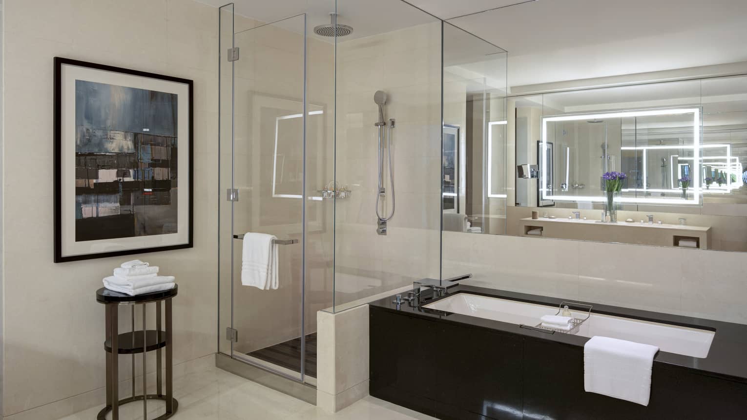 Bathroom with built-in tub, glass enclosed shower, artwork