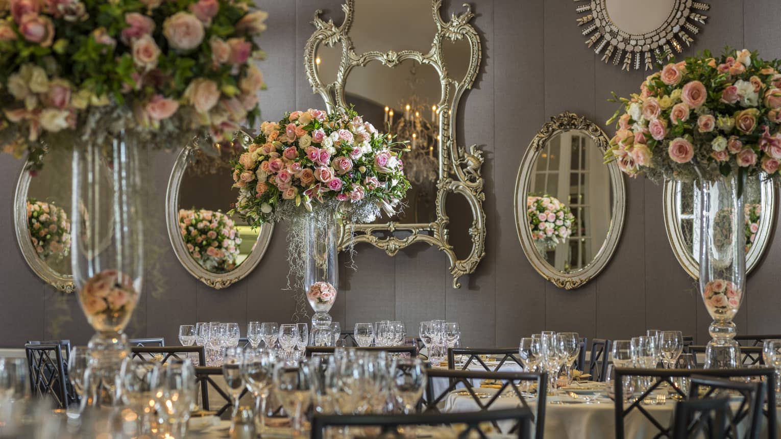 Arcadia Ballroom with wall of antique style mirrors over banquet dining tables with pink roses