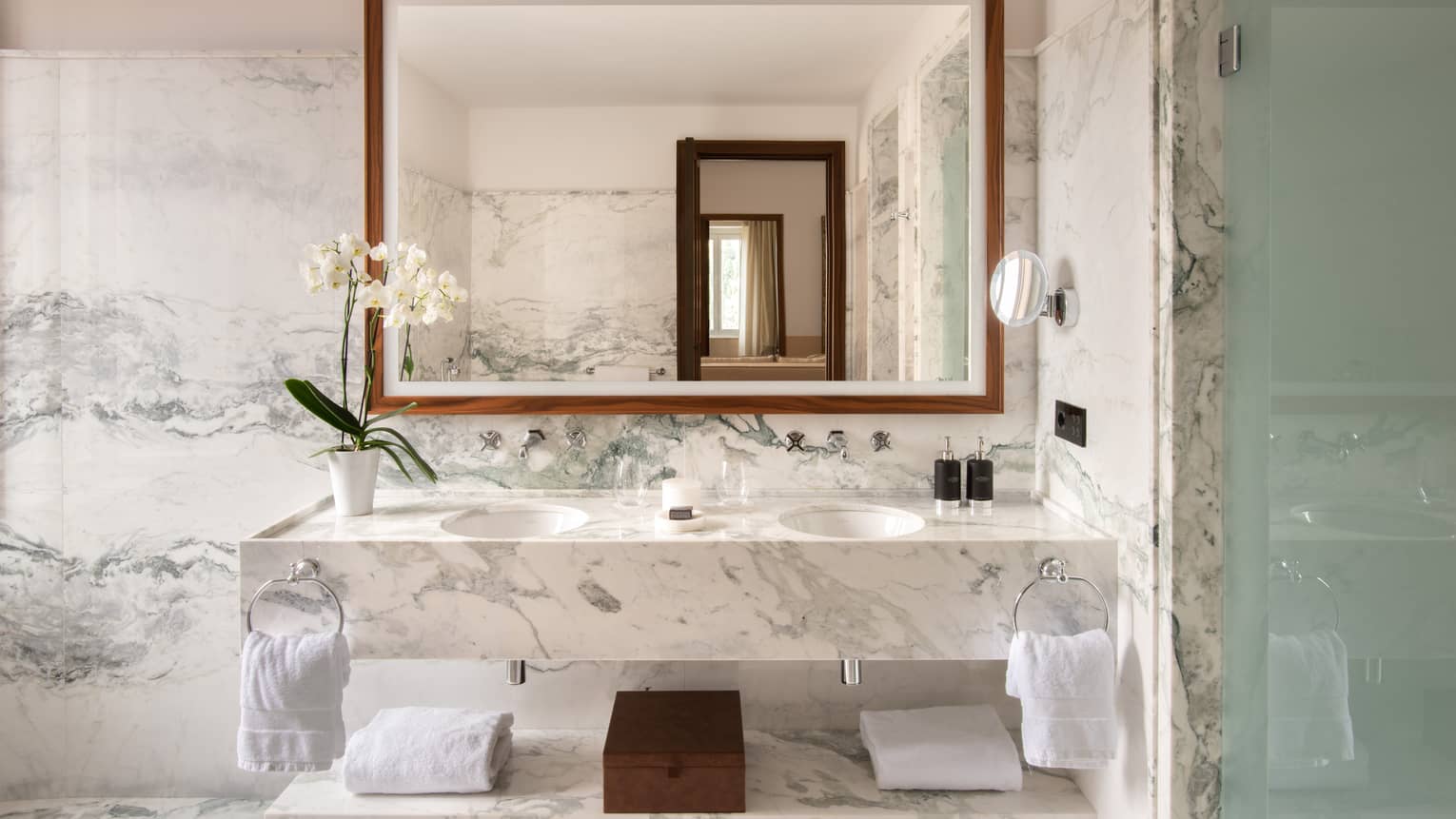 Bathroom with marble vanity, walls and floor, large mirror, two sinks