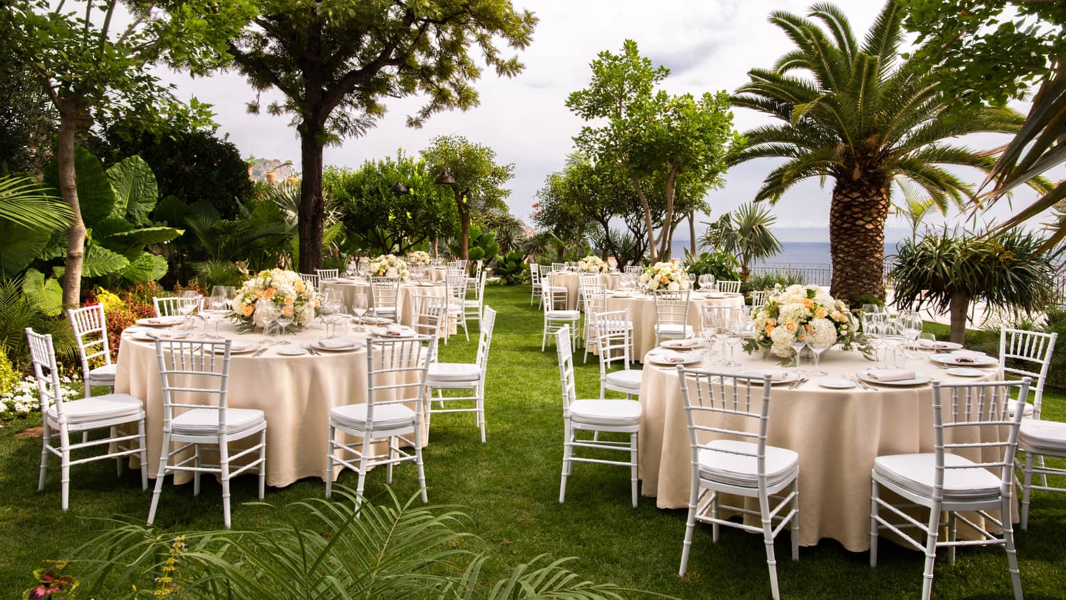 Outdoor wedding banquet with palm trees, sea view