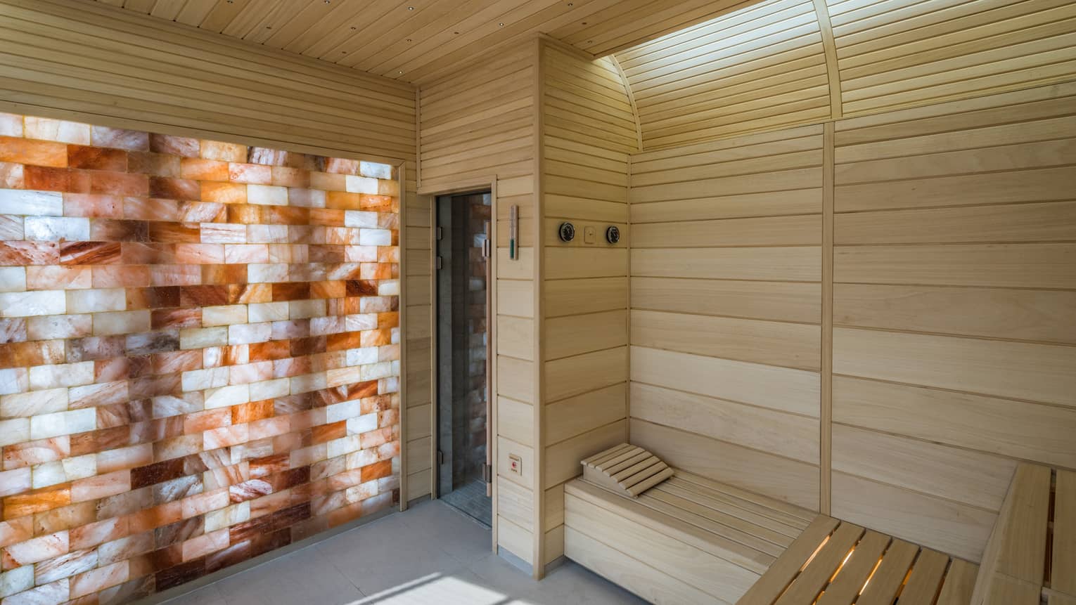 The Club wood sauna room with illuminated wall with wood, brick pattern