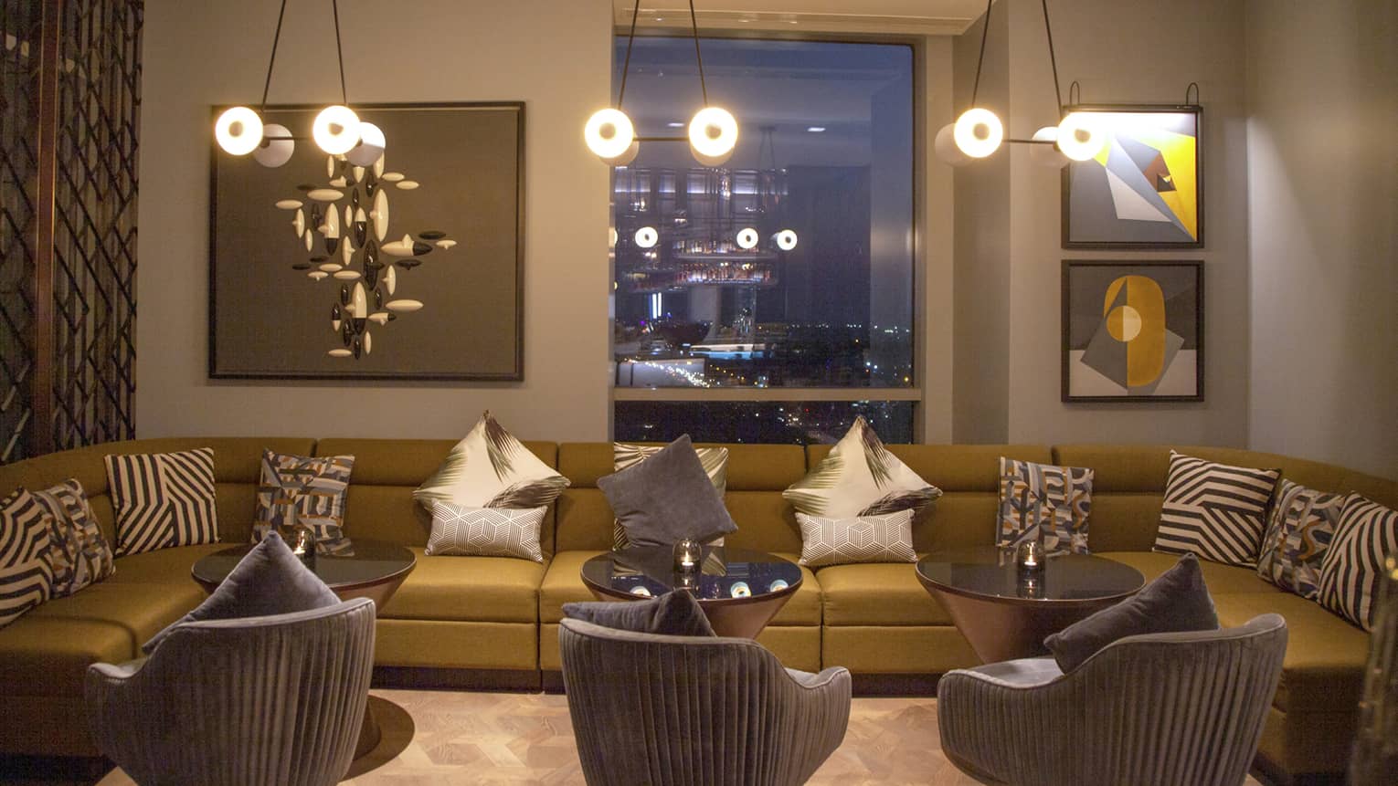 Copitas bar with long modern modular sofa, velvet armchairs under lights 