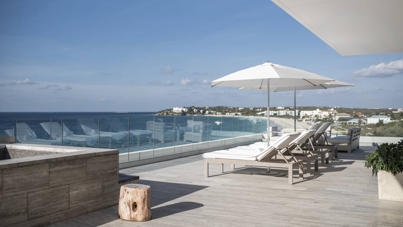 Private sea-view terrace with grey slate floors, four sun loungers and two umbrellas