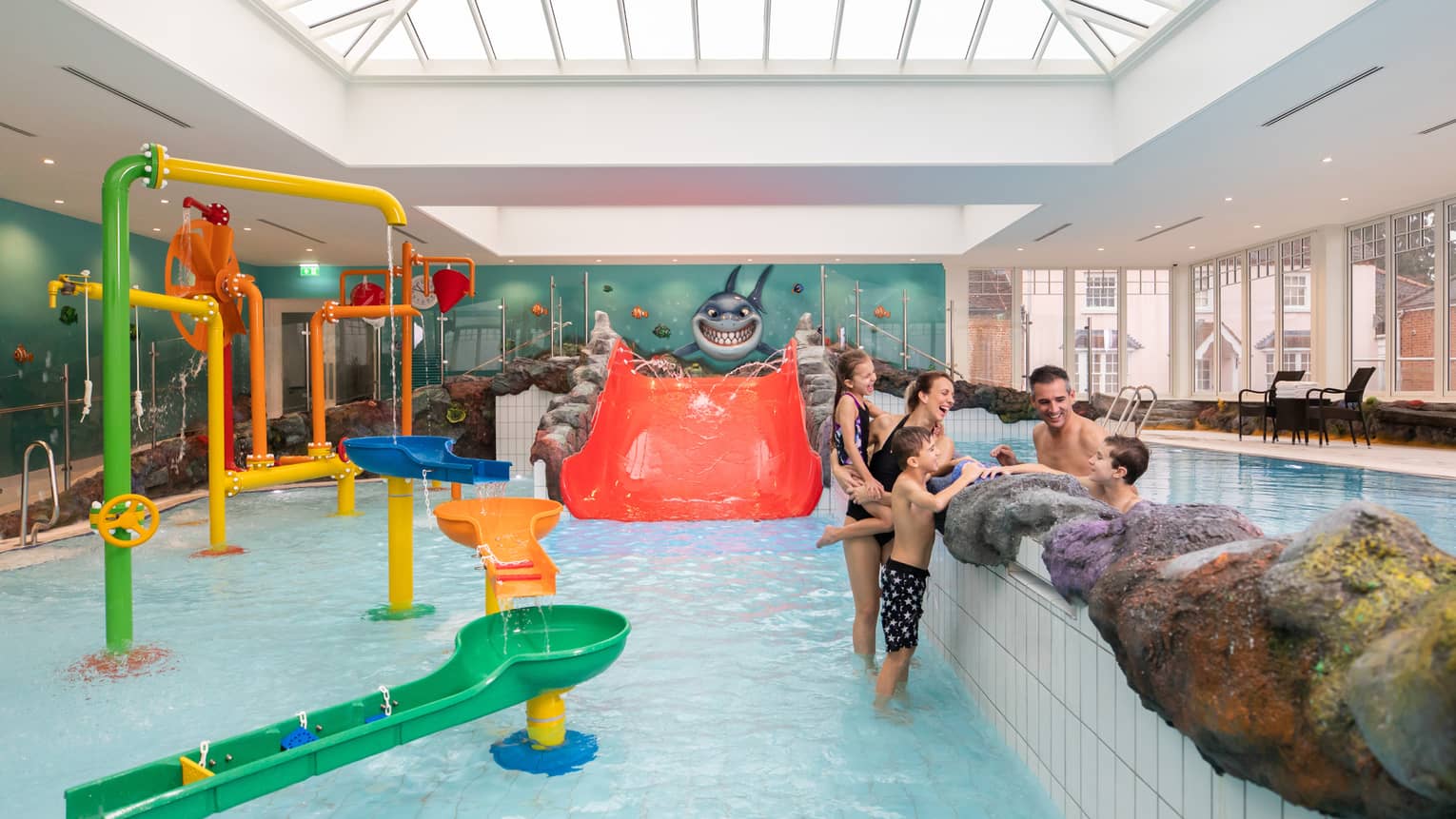Family talking while standing in Sharkie's colourful indoor pool