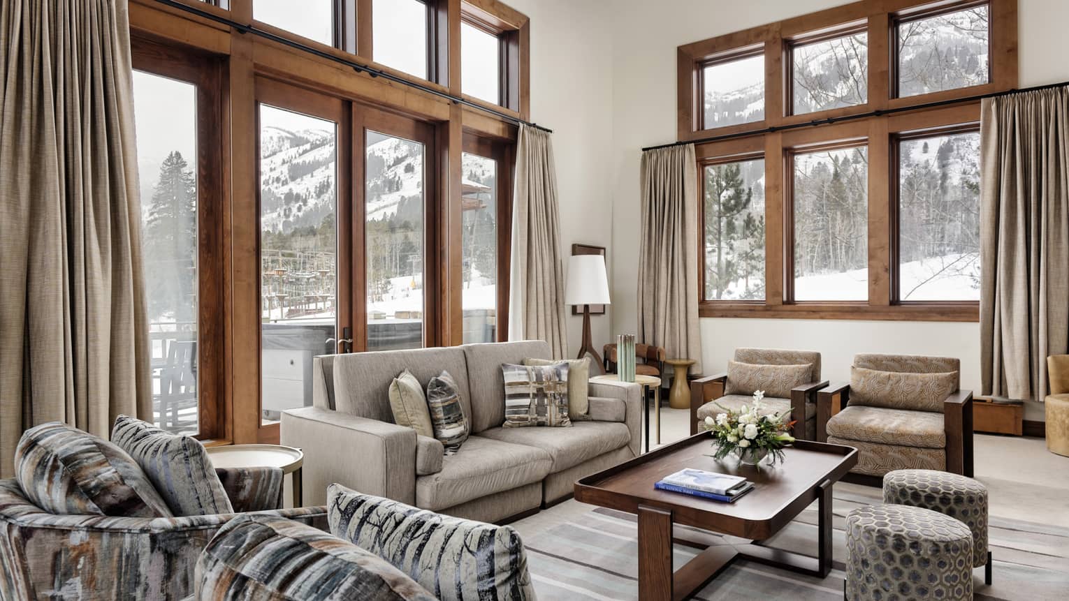 Large living room with wooden-framed windows, views of Jackson Hole ski slopes