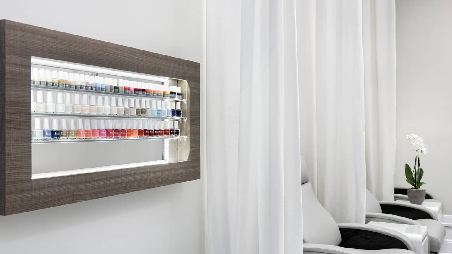 A wall with nail polish on shelves.