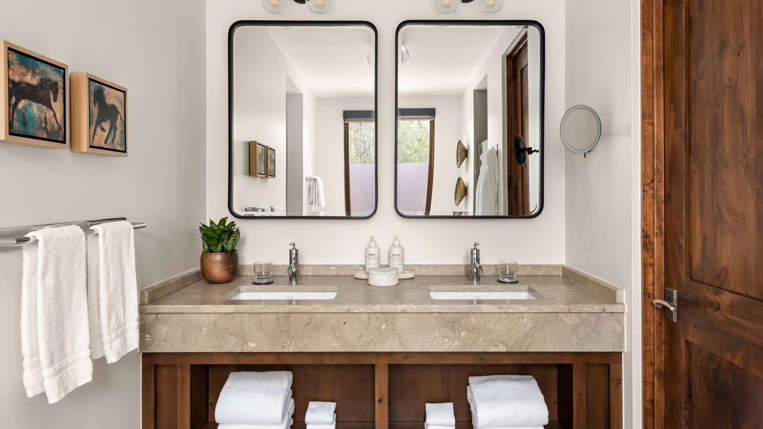 Bathroom with double vanity, two metal-framed mirrors and wooden shelves