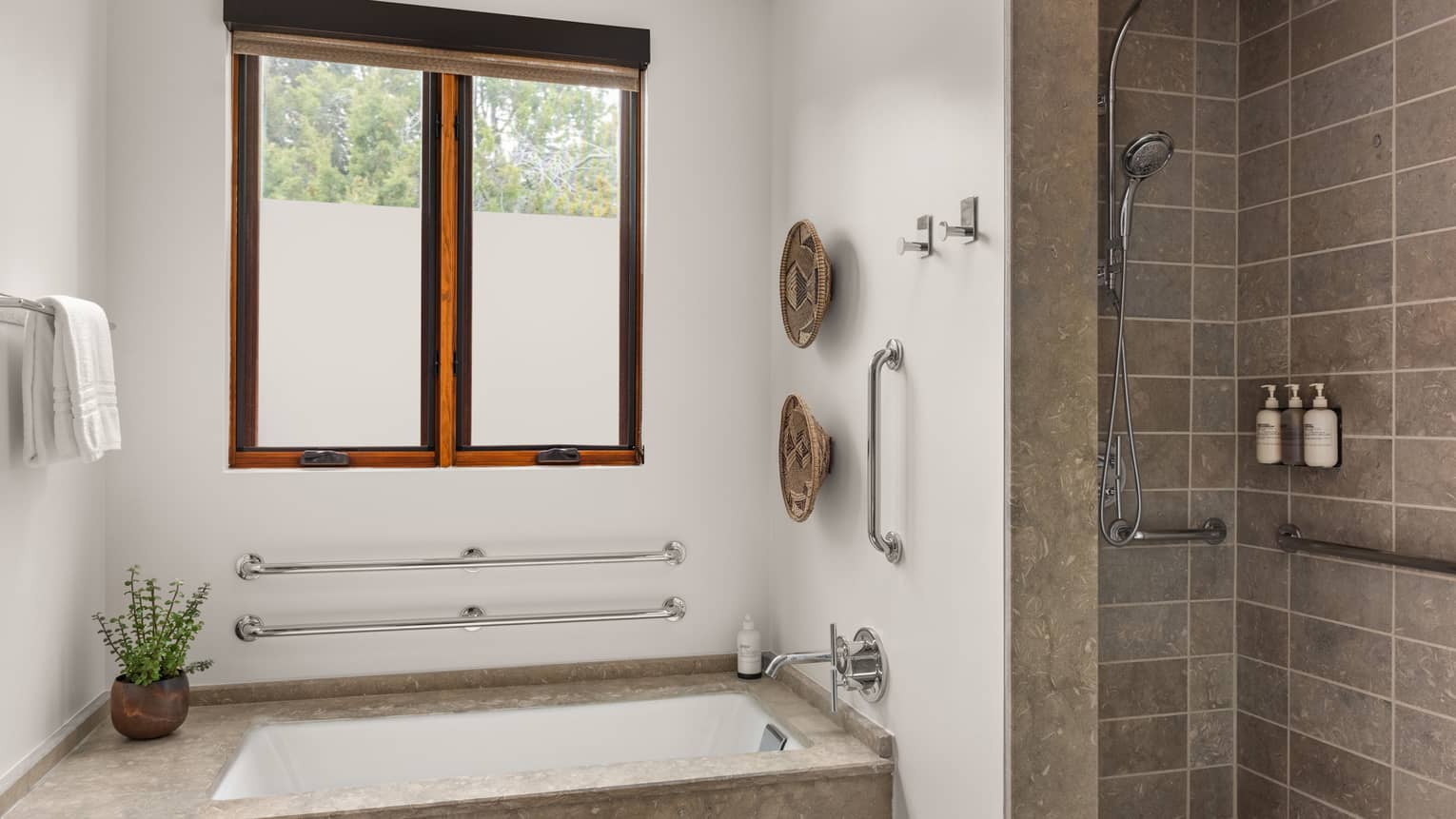 Accessible bathroom with tub, grab bars, window and shower at Four Seasons Resort Santa Fe