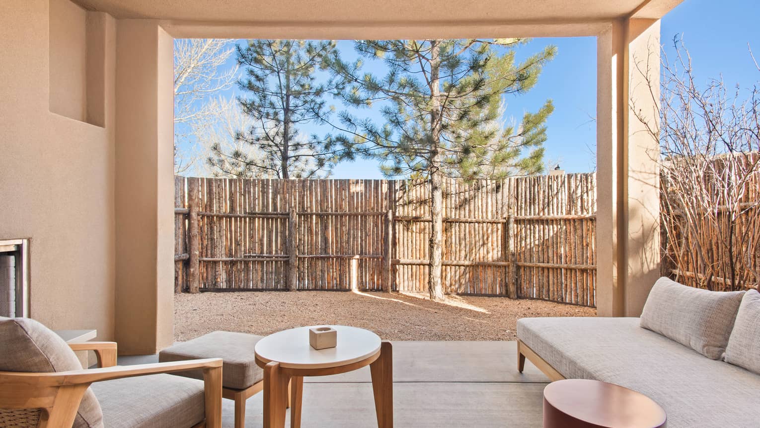 Private patio of a Casita Room, complete with fireplace and lounge chairs, at Four Seasons Resort Santa Fe