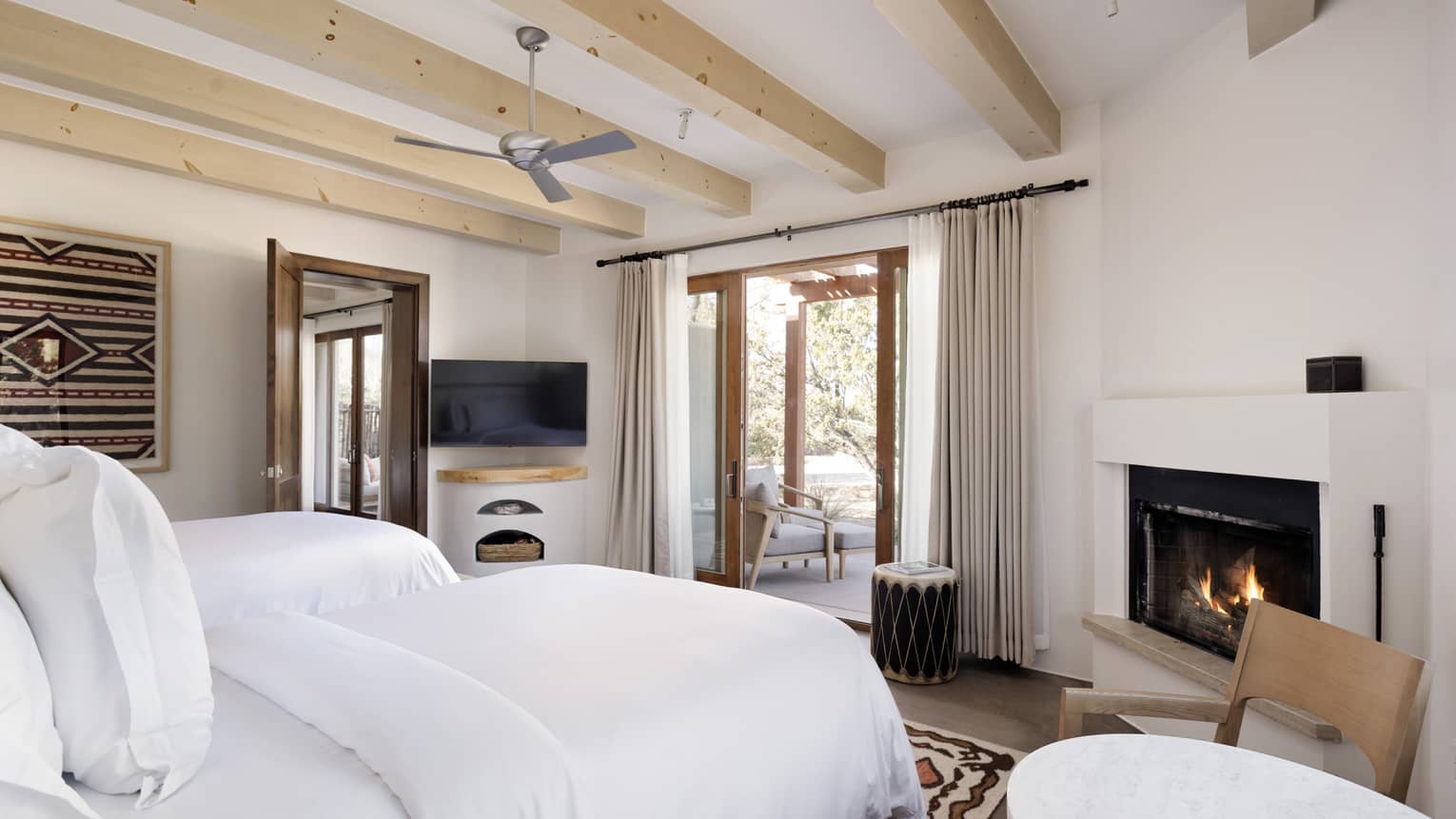 Guest room with king bed, fireplace and walk-out terrace at Four Seasons Resort Santa Fe