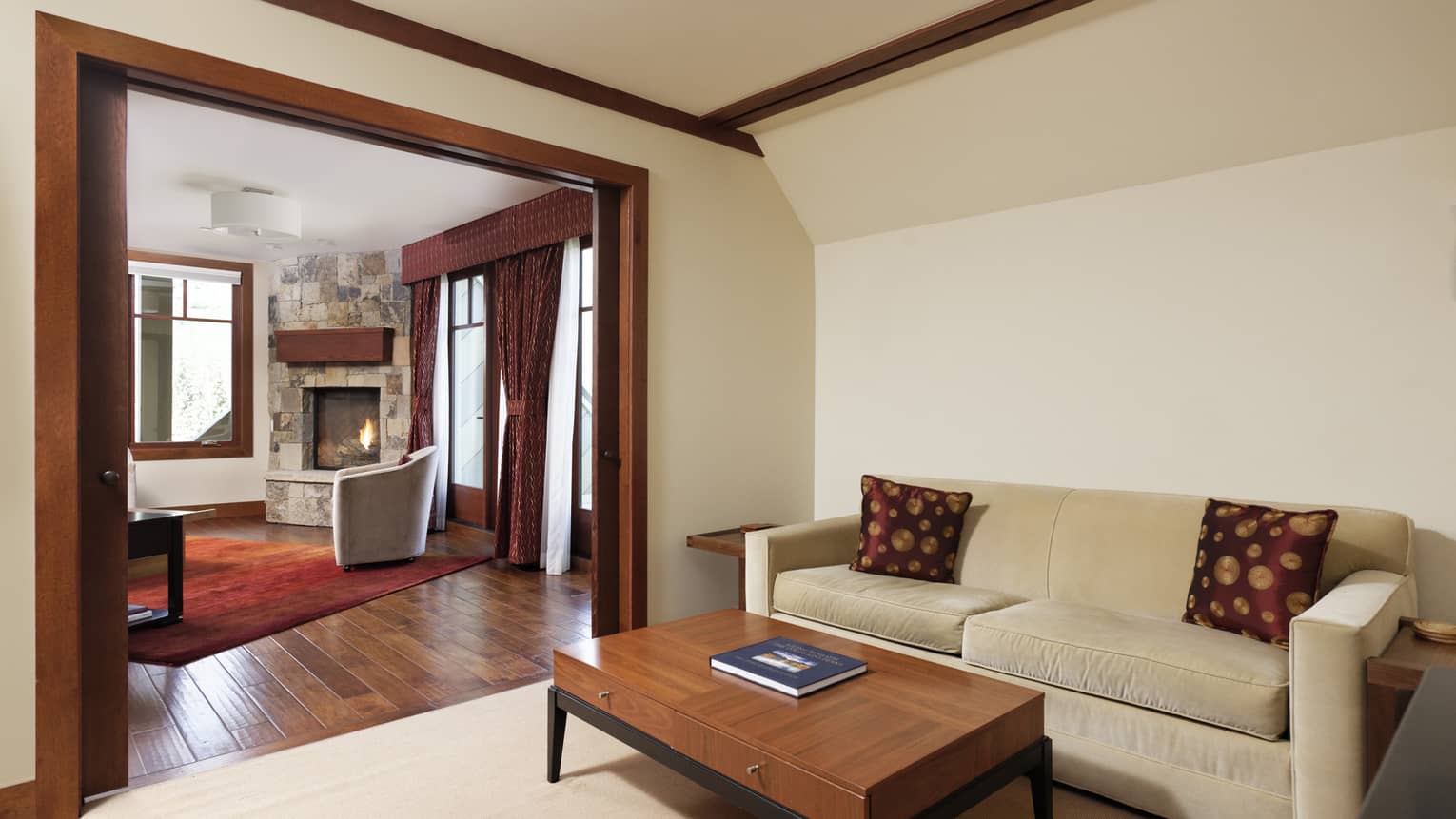 Room with cream-coloured sofa, wooden coffee table, cream walls, dark wooden molding