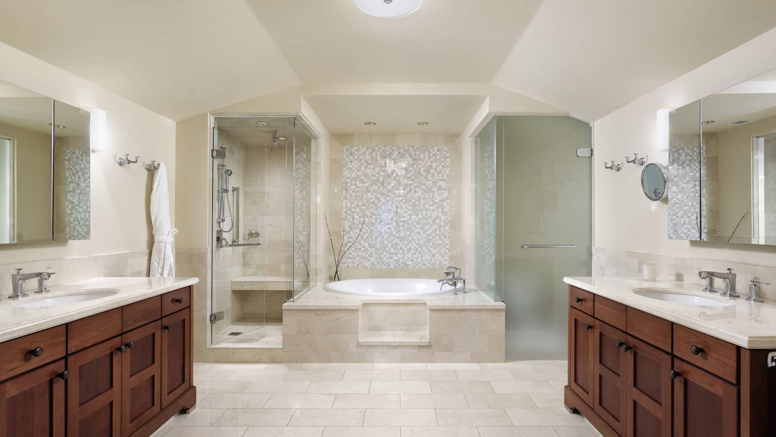 Large bathroom with tub in center, showers on either side, long vanities on either side
