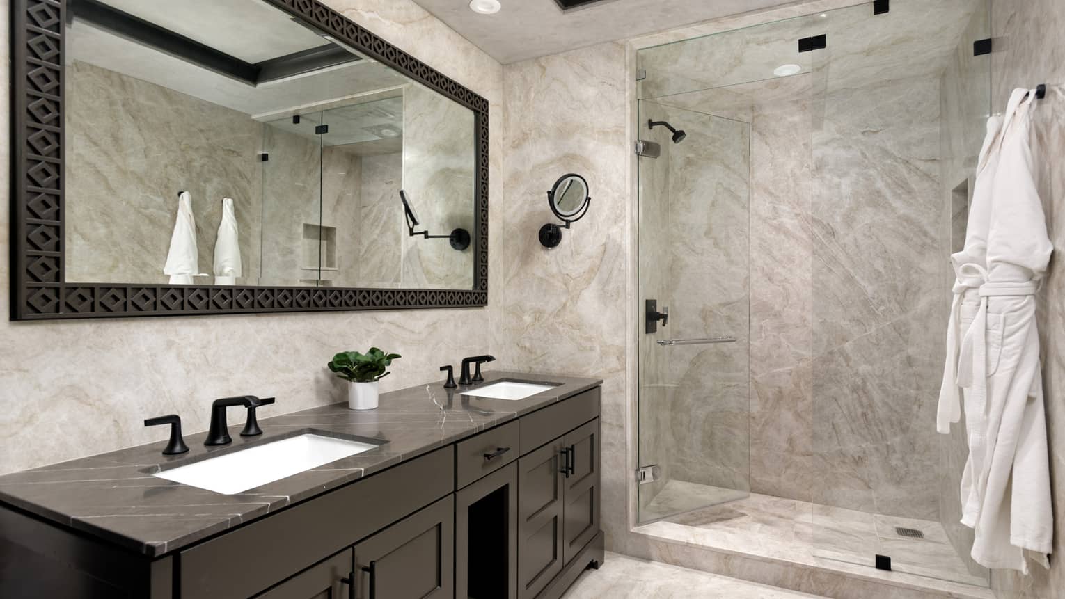Bathroom with granite walls, walk-in glass shower, hanging robes, double vanity