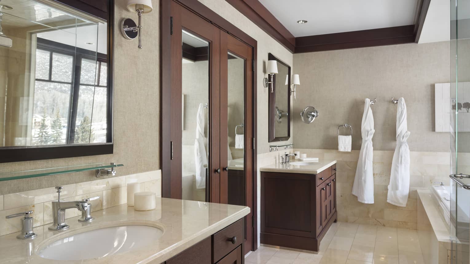 Bathroom with two separate vanities, light tile, shower and tub
