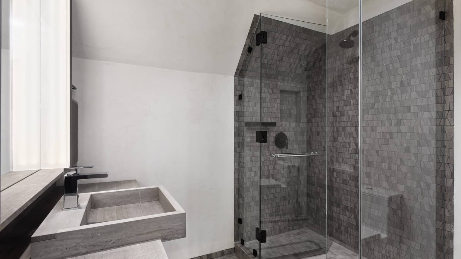 Stone tile walk-in shower with glass doors