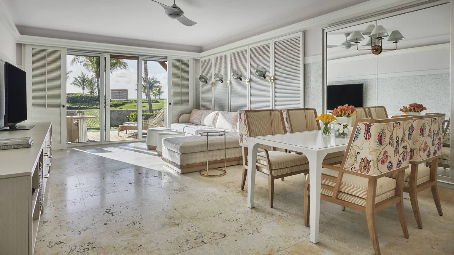 Spacious suite with marble floors, modern beach decor, glass patio doors to garden
