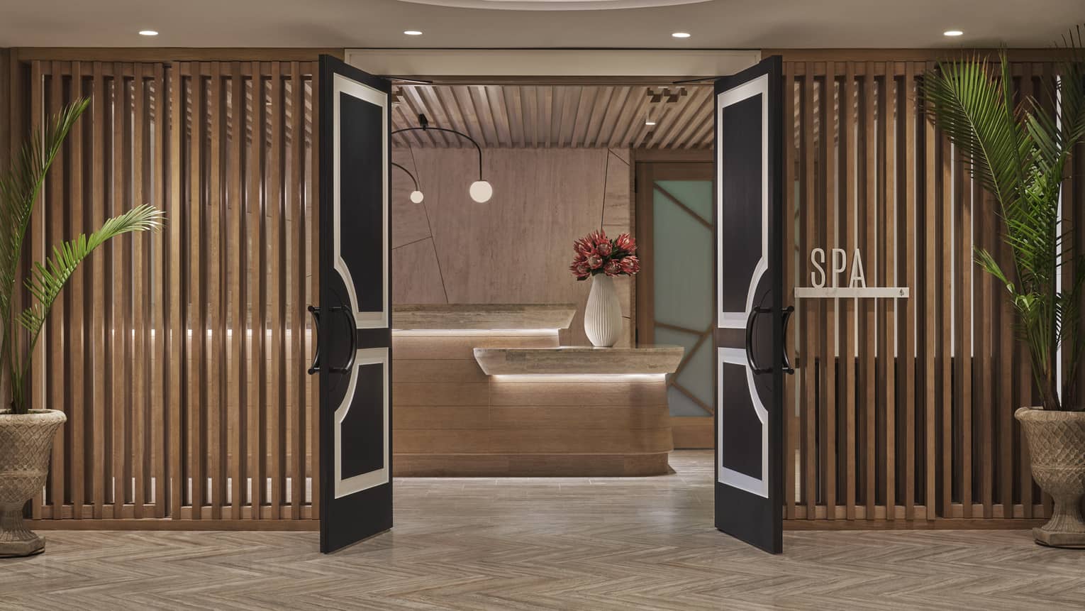 The entrance to a spa at a hotel, dark wood doors with wooden beams acting as walls.