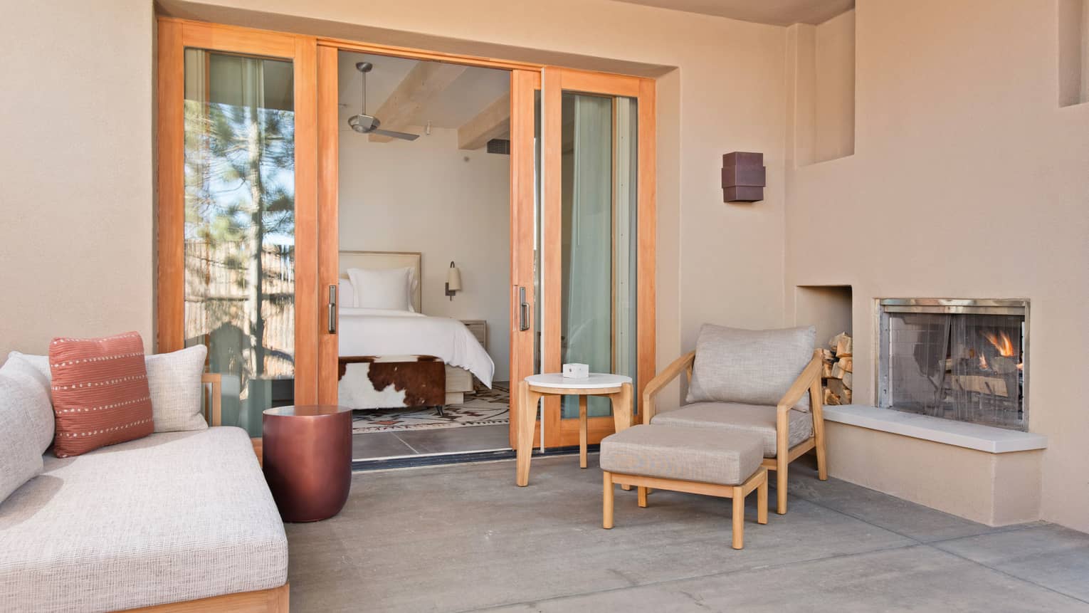 Private patio of a Casita Room, complete with fireplace and lounge chairs, at Four Seasons Resort Santa Fe