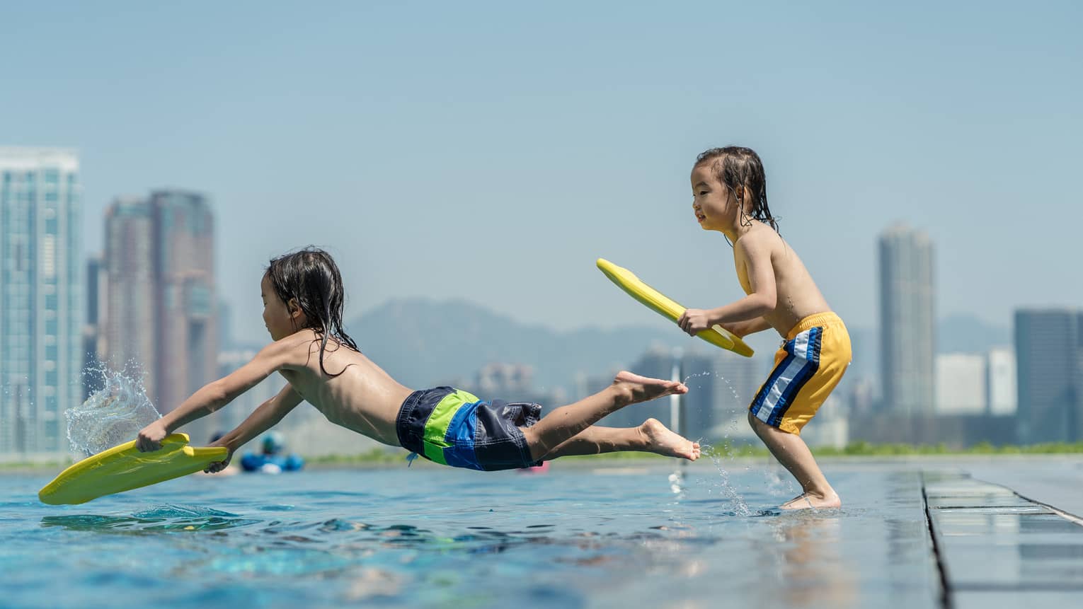 Two young boys play in outdoor hotel pool