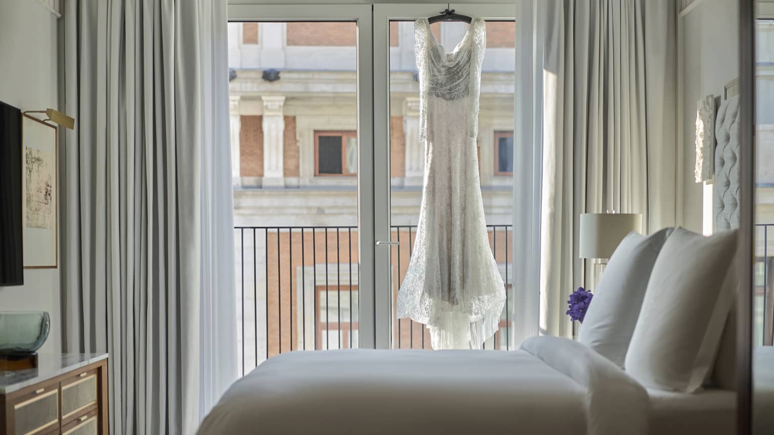 A wedding dress hangs in the window of a deluxe suite.