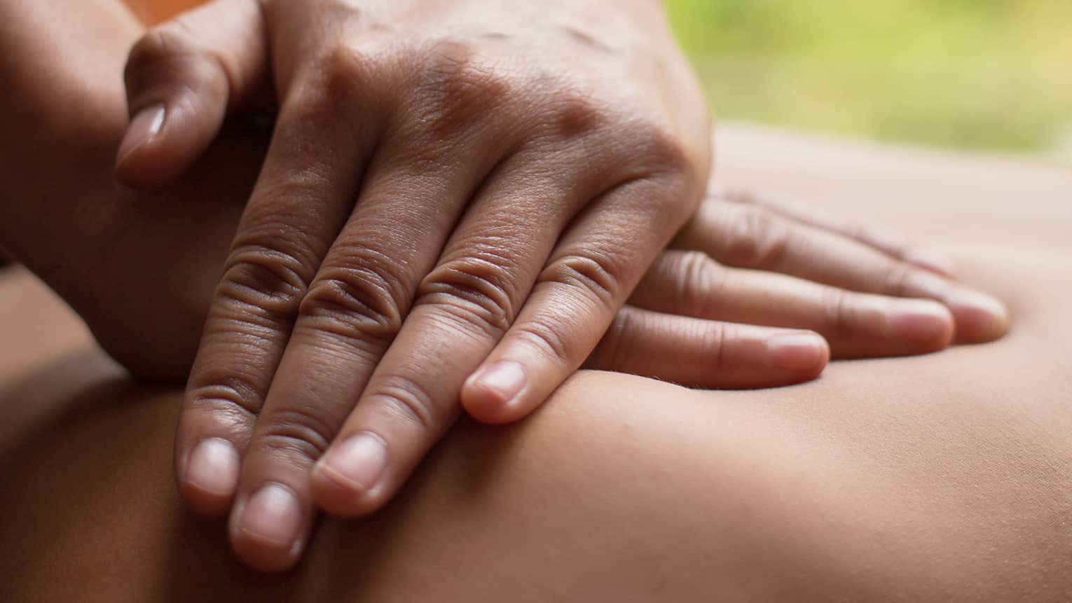 Close up of hands massaging a back