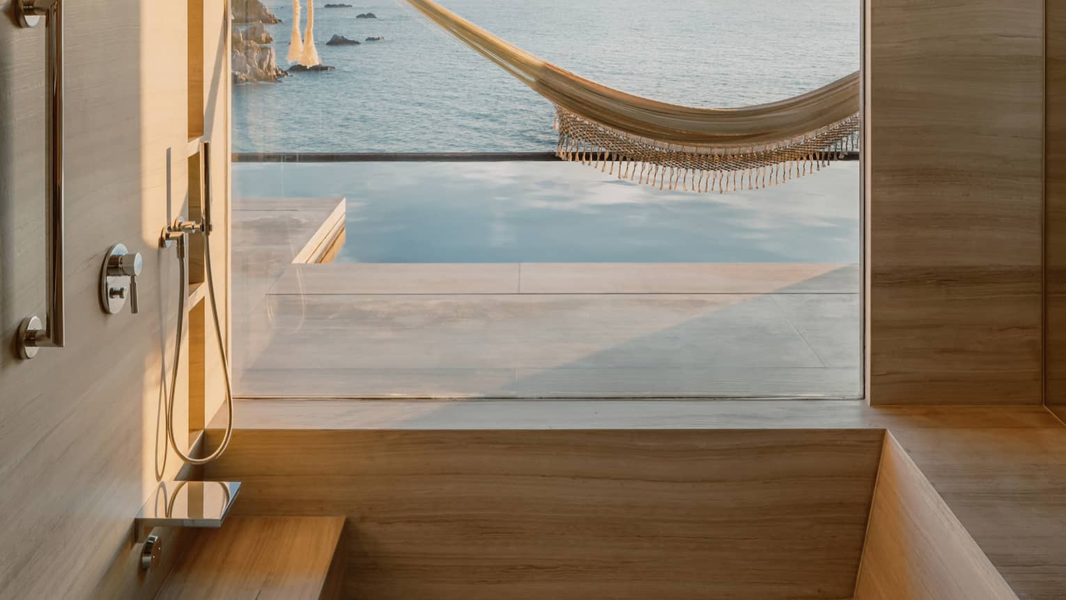A bathroom opens to an ocean-view terrace with pool and hammock
