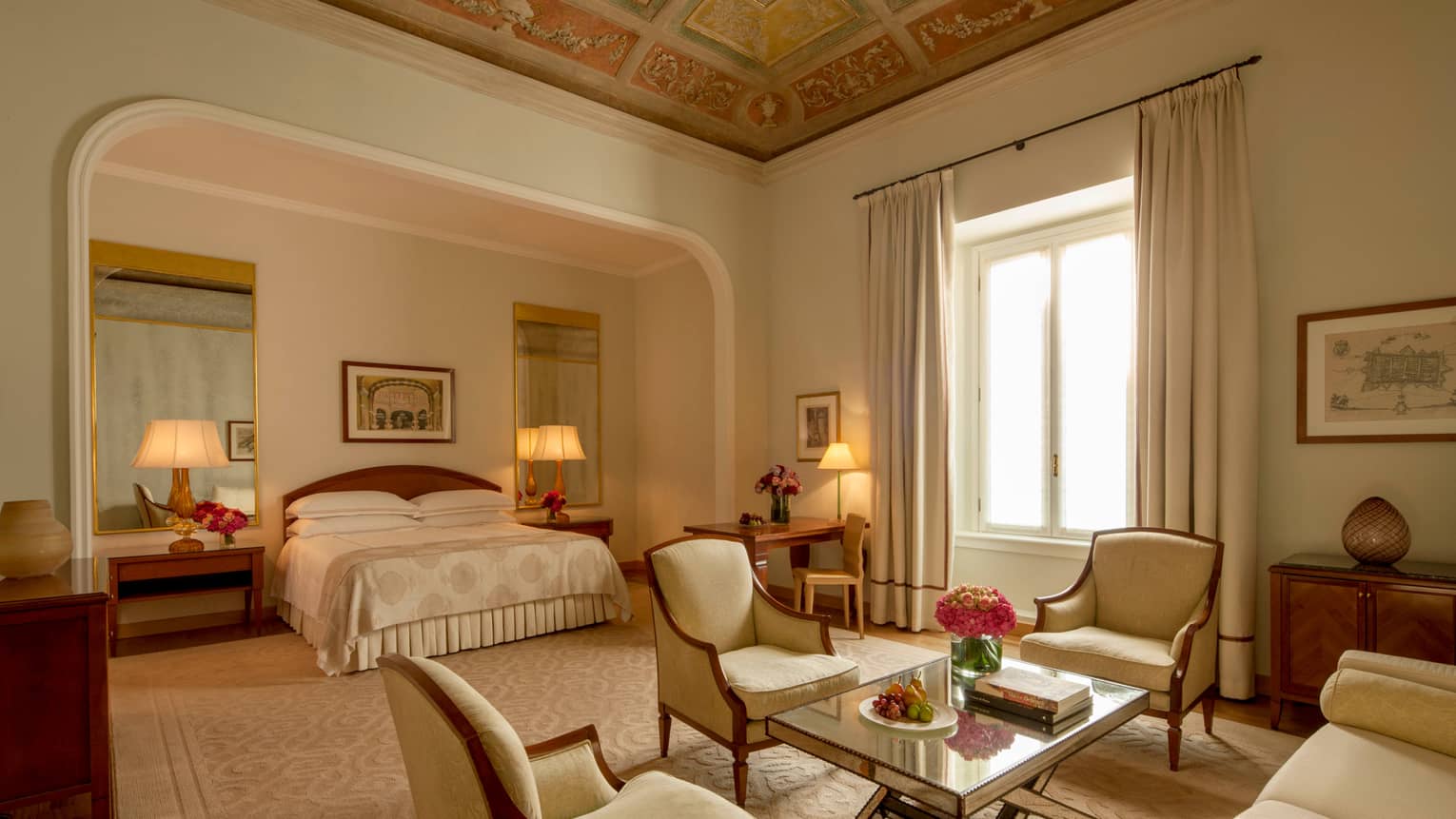 Fresco Suite soaring ceilings, bed in alcove with mirrors, antique-style ivory armchairs around table