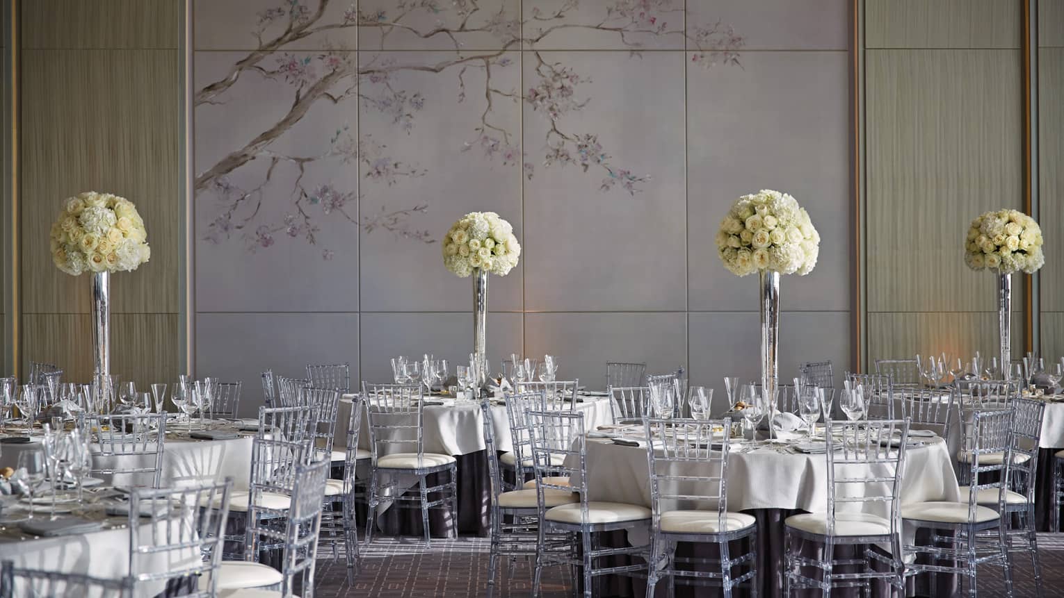 Vinci ballroom banquet dining tables with tall white flowers, accent wall