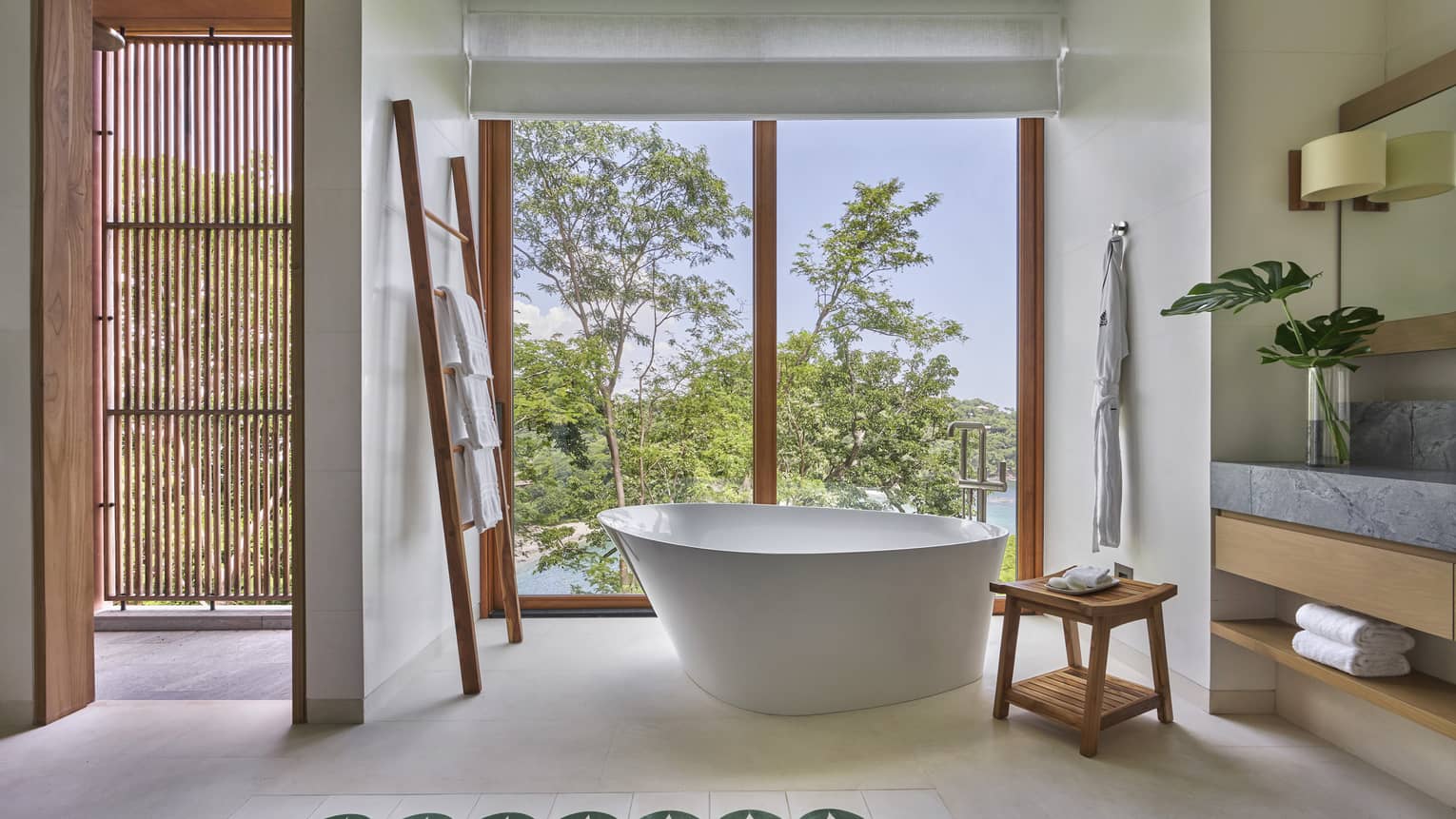 Bathroom with a free-standing tub by a wall of windows