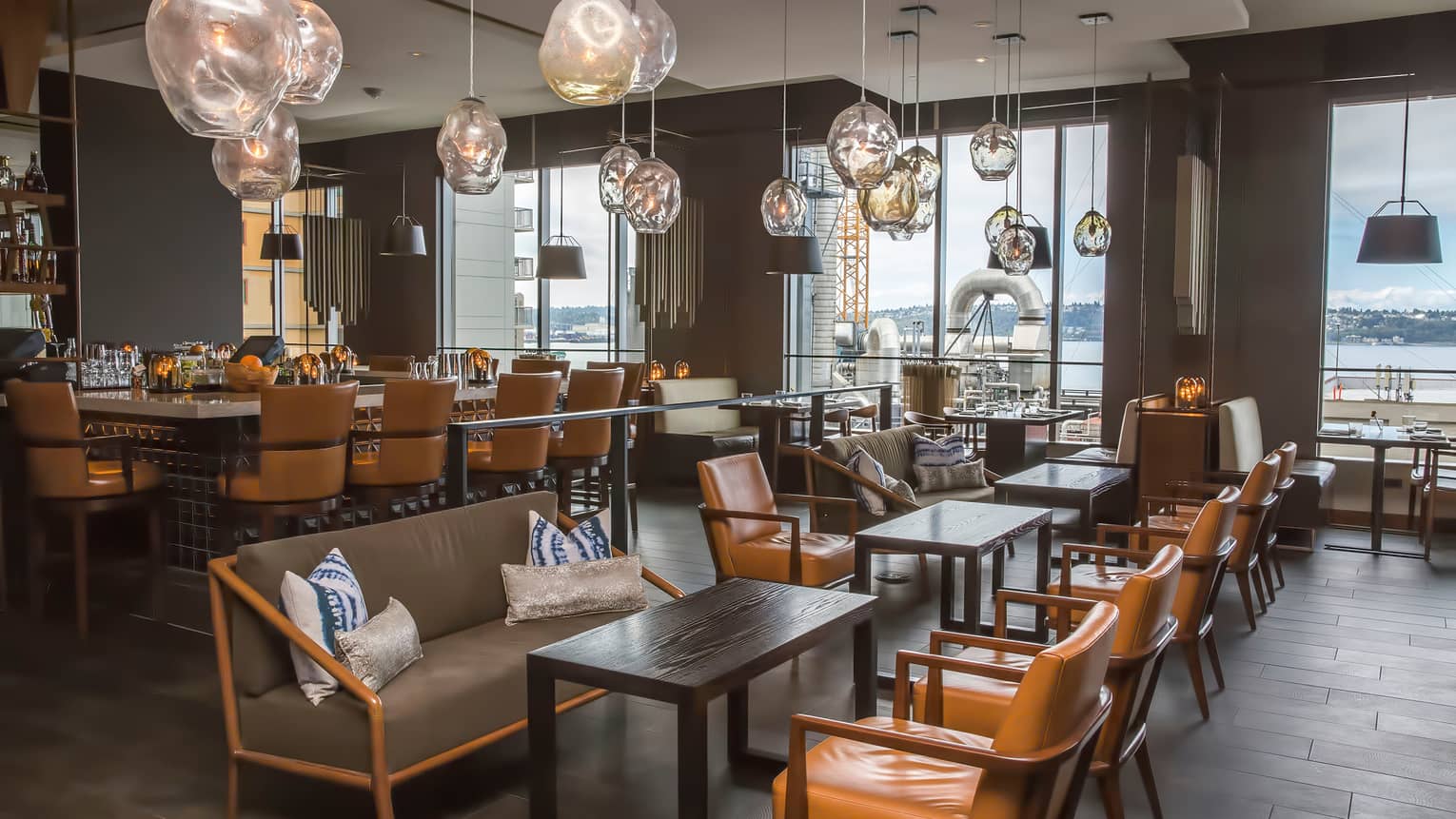 Amber-tinged glass lamps hang above Goldfinch Tavern dining tables, leather chairs