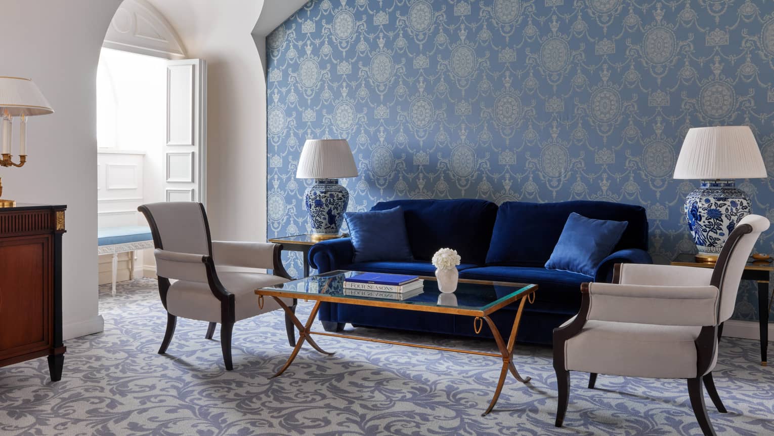Living room with dark blue sofa, two chairs and blue wallpaper