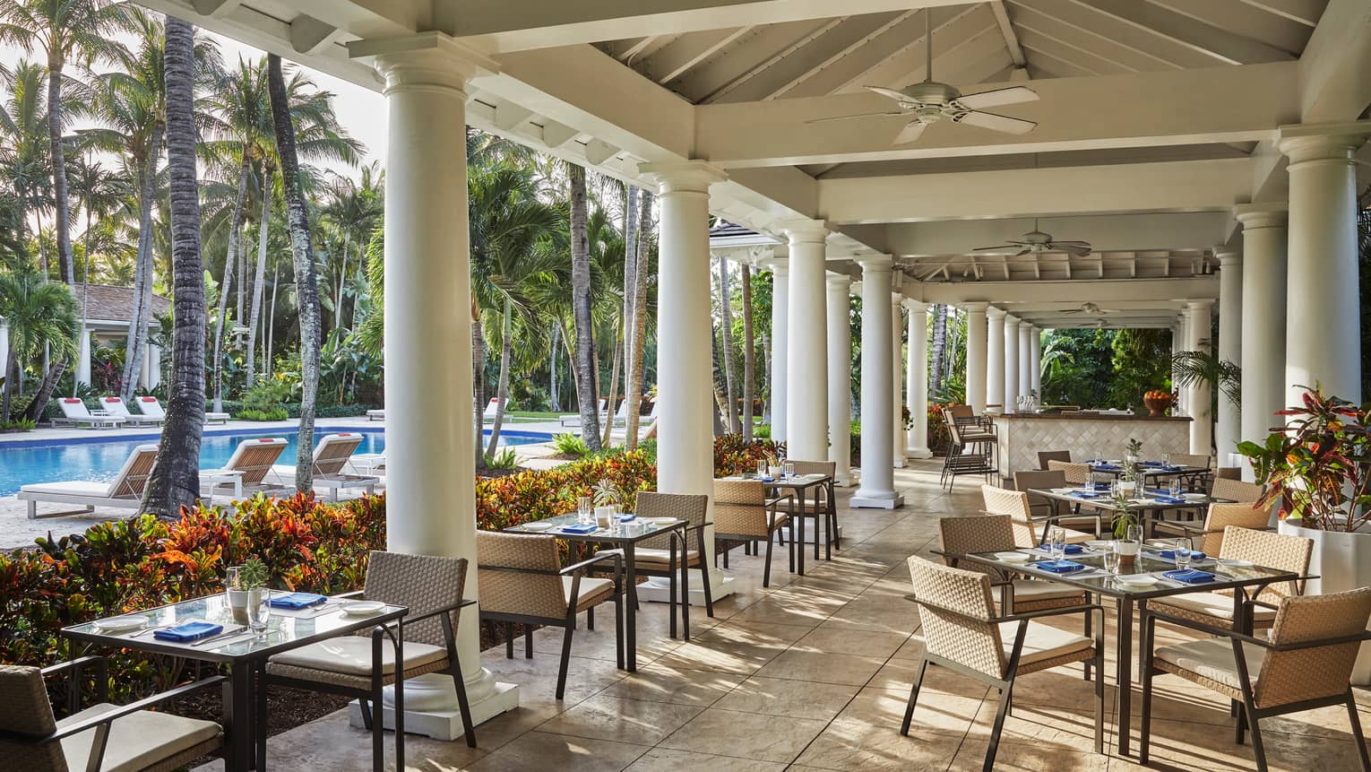 Versailles Terrace restaurant patio, tables under white pillars, ceiling, near swimming pool
