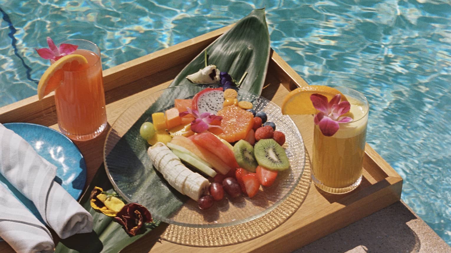 Tray of food and drinks by the pool.