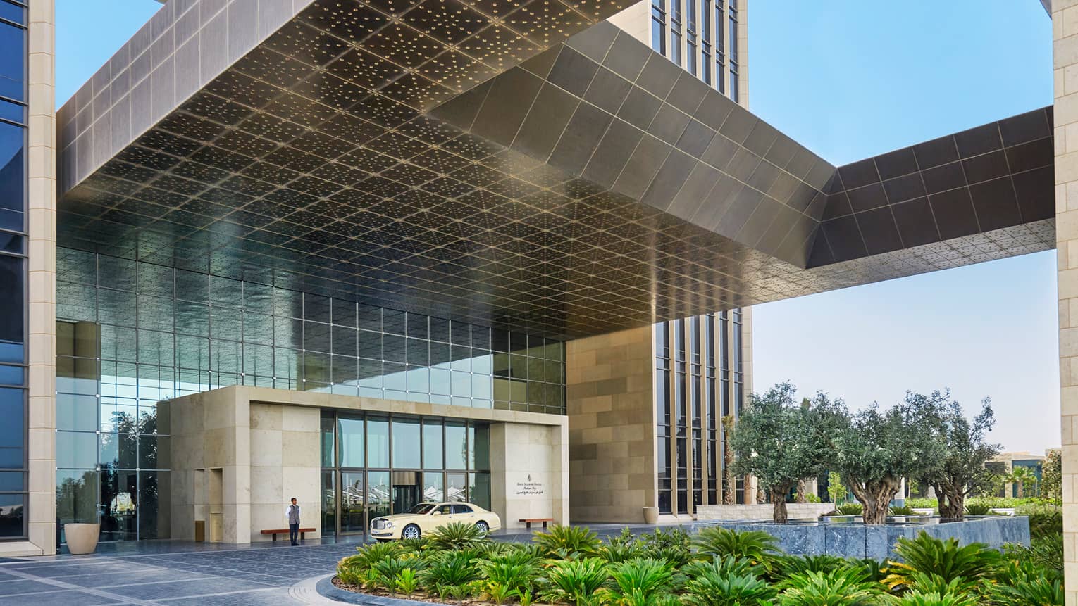 Four Seasons Hotel Bahrain Bay front entrance, car in front of door, door person, tropic garden