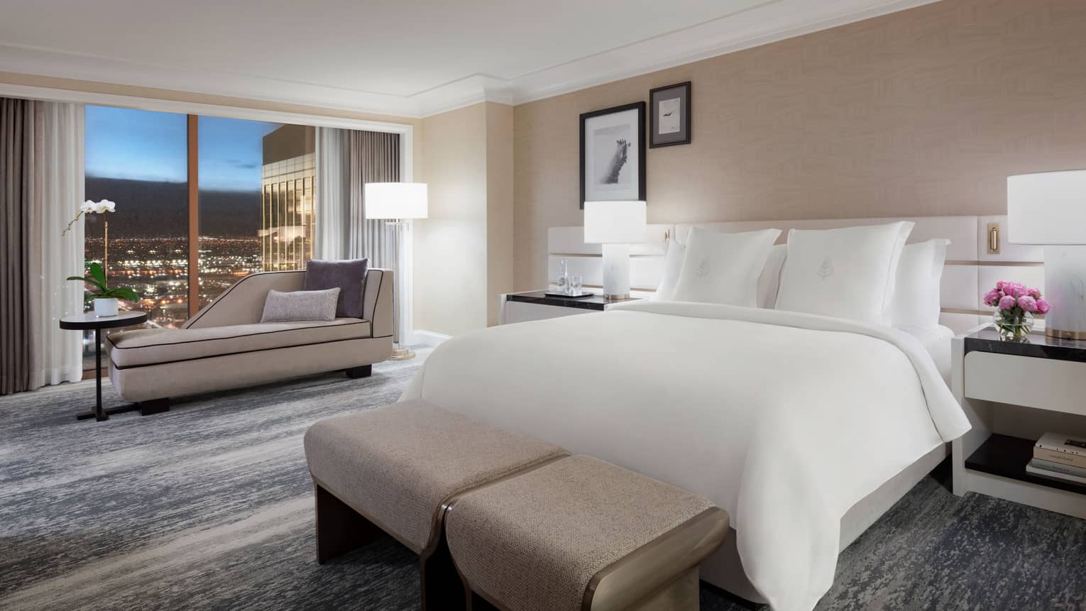 Modern bedroom with king bed and windowside chaise at Four Seasons Hotel Las Vegas