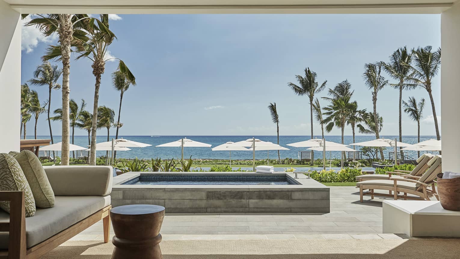 Pacific Suite open to wall to patio with stone plunge pool, lounge chairs, ocean views
