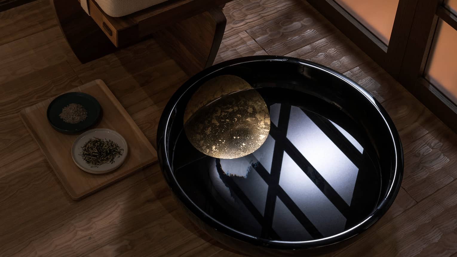 Light reflected in black bowl with water in spa