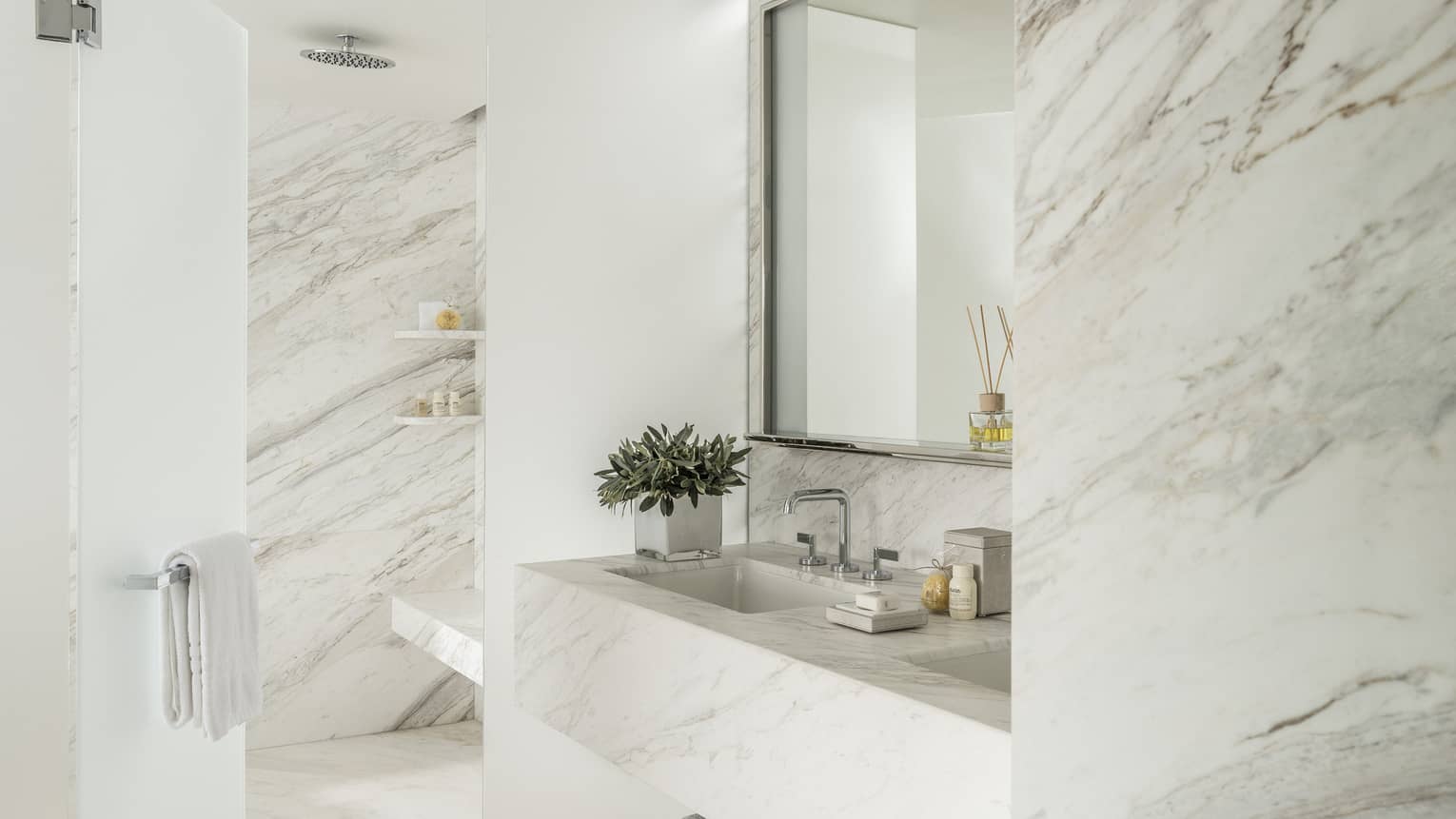Arion Corner Suite Bathroom with marbled double vanity and full-width mirror