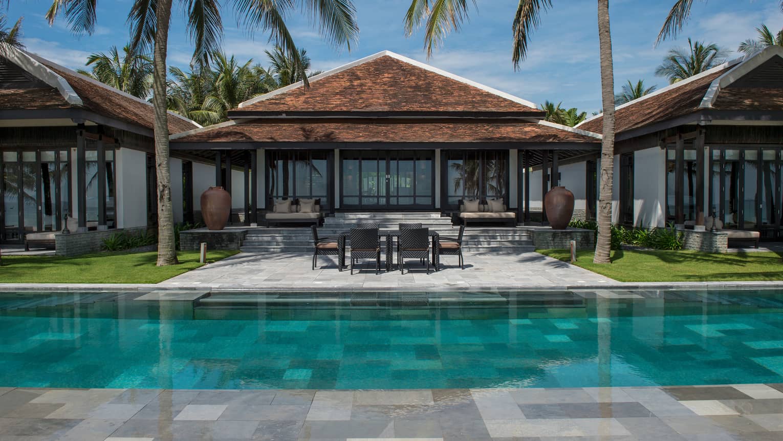 View of Ocean View Pool Villa exterior, patio under palms, from outdoor pool