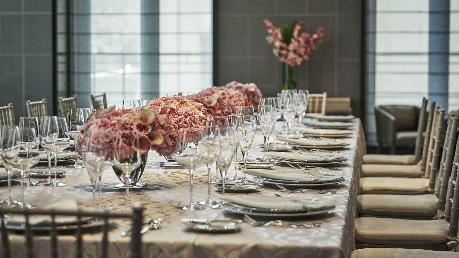 Banquet table with elegant dishes, wine glasses, pink floral arrangements in Chambers room