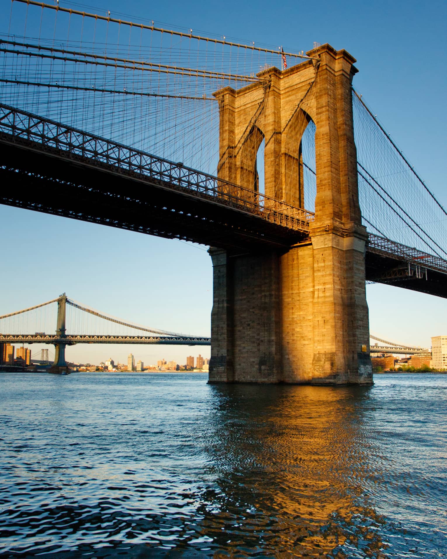 The Brooklyn Bridge at sunset on the water 