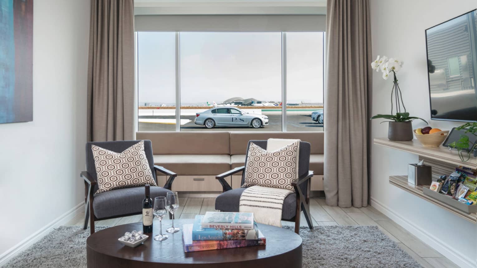 Private airport Suite seating area, car and runway in background through window