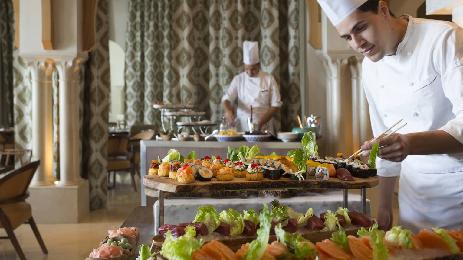 Chef places Brunch Sushi on buffet platters in dining room