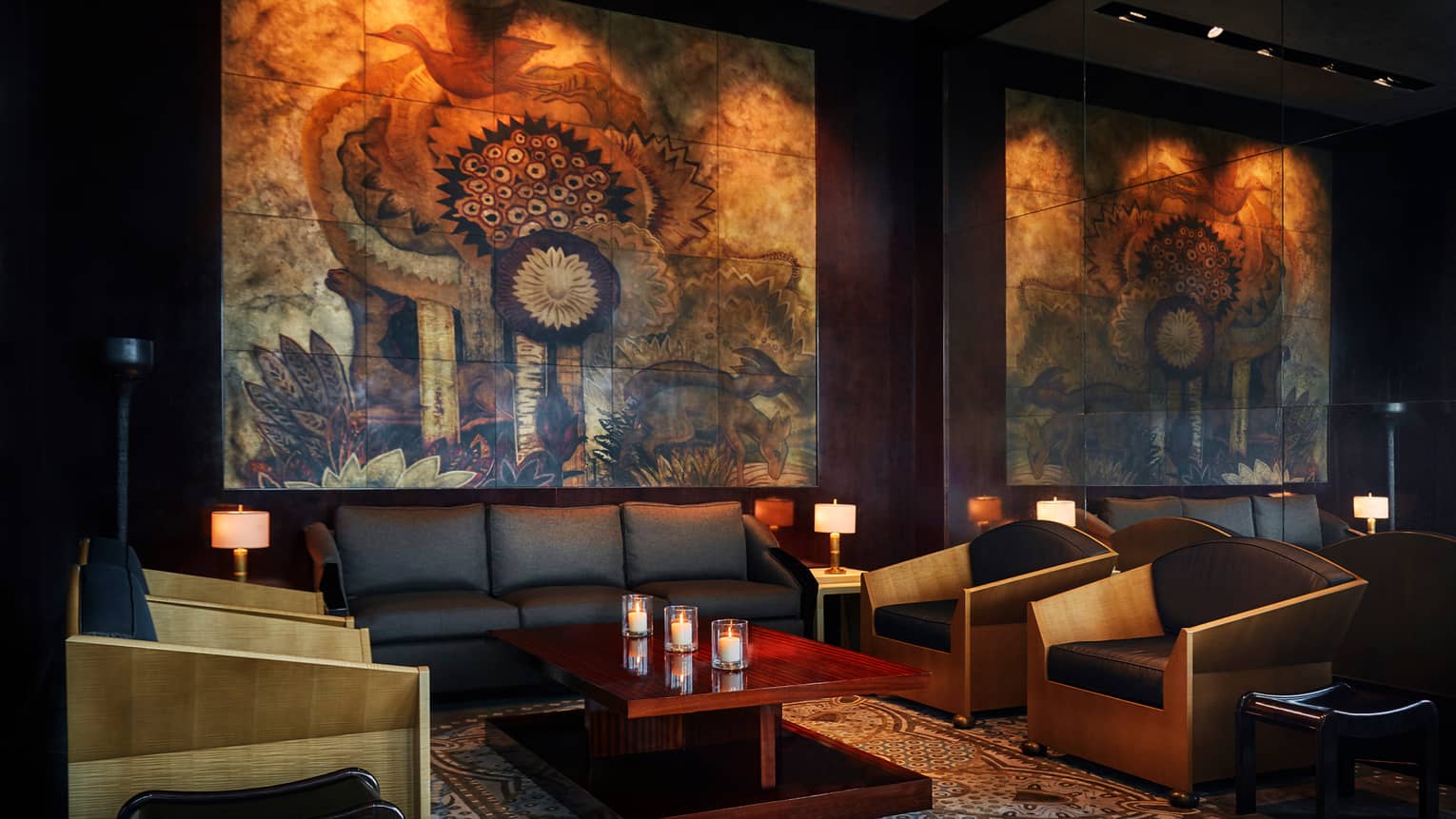 CUT by Wolfgang Puck dimly-lit lounge area with leather sofas and chair, large mural