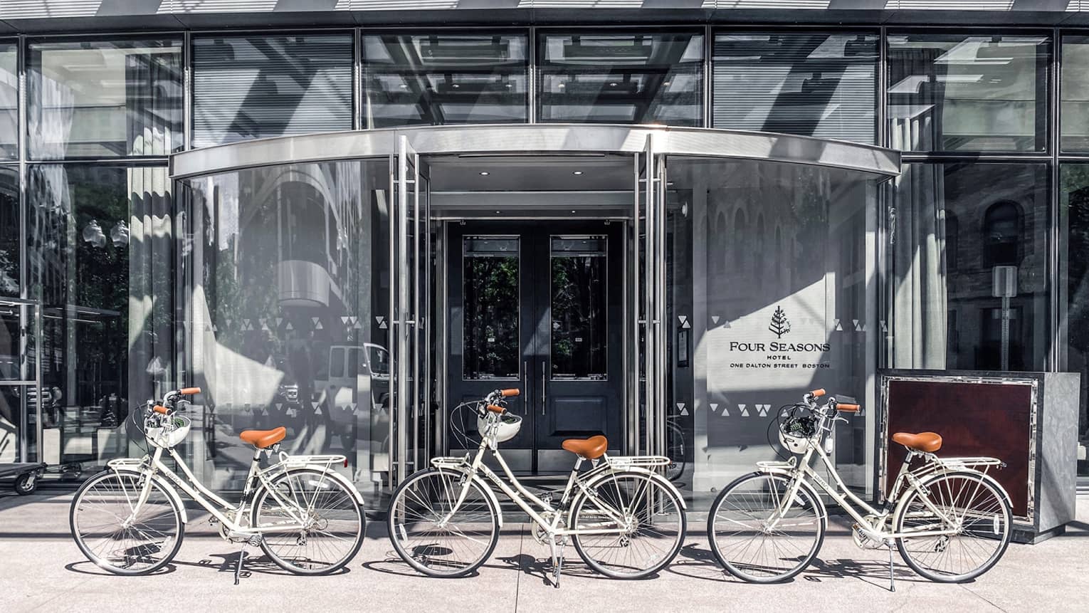 The bicycles in front of a four seasons hotel entrance.