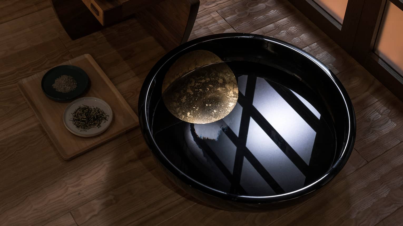 Light reflected in black bowl with water in spa