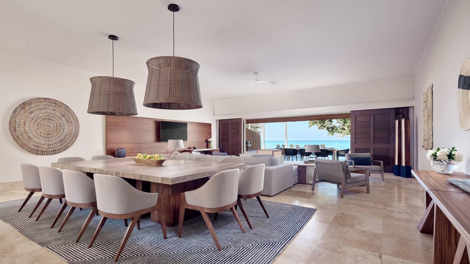 Arena Beach House combined living/dining room with grey area rug, cream and wooden accents