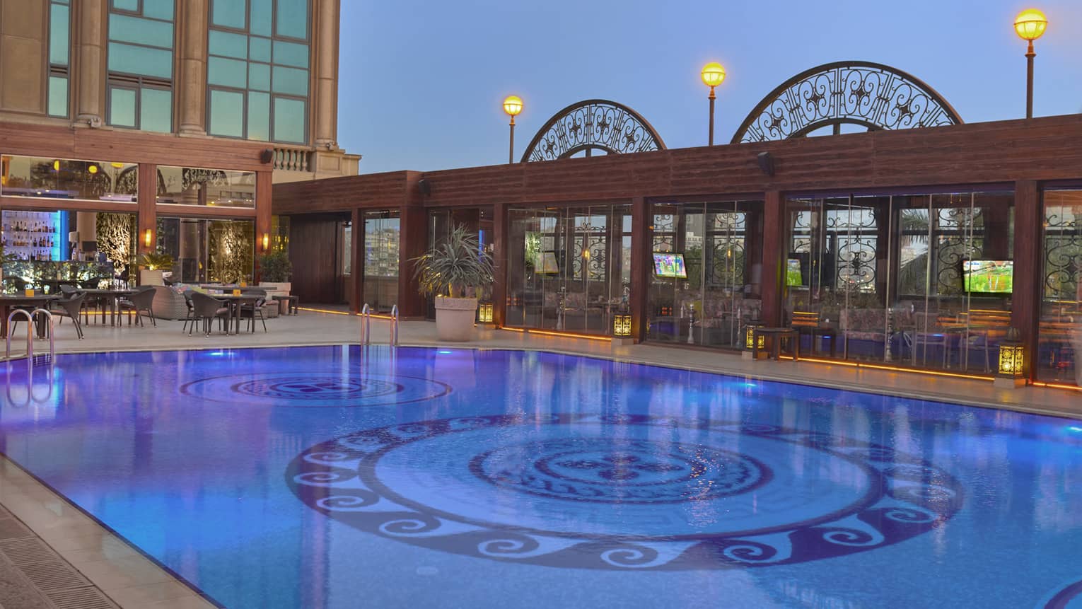 Outdoor pool illuminated under moonlit sky