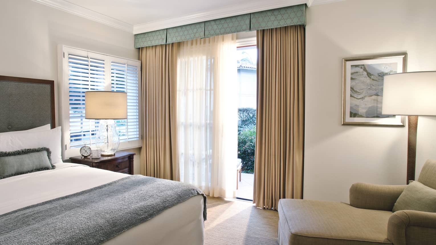 Guest room with queen bed, blue & white linens, chaise, floor-to-ceiling windows 