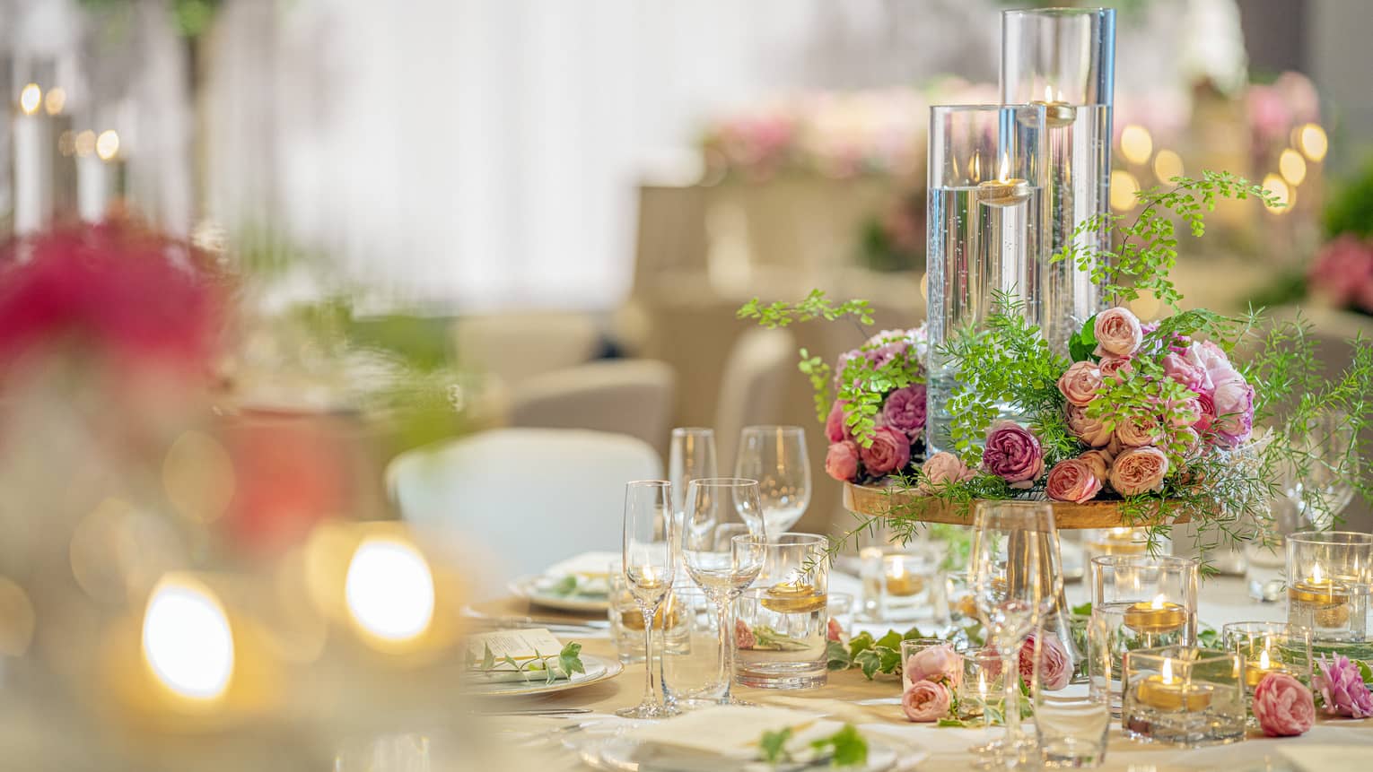 Closeup of table in ballroom with gold accents and pink floral centrepiece